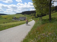 Ein Radler passiert ein Gehöft im schönen Nordschwarzwald.