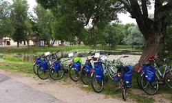 Abgestellte Fahrräder mit blauen Satteltaschen vor einem See in Masuren.