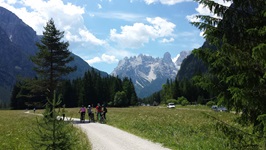 Radlergruppe vor der imposanten Bergkulisse der Dolomiten.