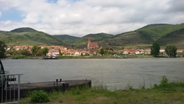 Blick über die Donau auf eine Stadt entlang der Radreise auf dem Donau-Radweg von Schärding nach Wien