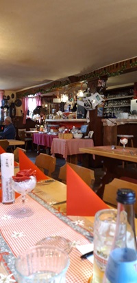 Blick in ein Gasthaus mit gedeckten Tischen