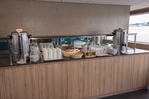 Buffet mit Getränkebehältern, Geschirr und Besteck auf der MS De Holland