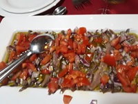 Frischer Tomatensalat mit Zwiebeln und Fisch, welcher auf dem Premiumschiff San Snova serviert wird