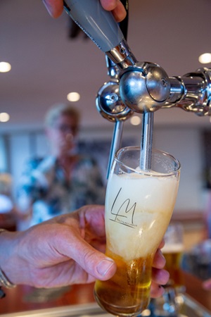 Ein Bier wird von der Zapfanlage der MS Lena Maria in ein Glas gezapft