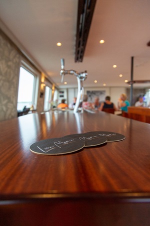 Detailbild von drei Bierdeckeln auf der Bar der MS Lena Maria
