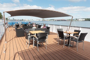 Blick auf das teilweise überdachte Sonnendeck der MS De Holland, auf dem ein zwei Gäste sitzen