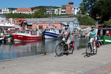 Ein Radlerpärchen passiert einen Hafen.