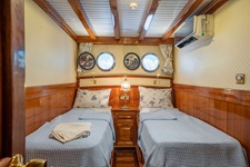 Blick in eine Zwei-Bett-Kabine mit Klimaanlage und Bullaugen auf dem Deluxeschiff Admiral