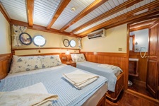 Blick in eine Drei-Bett-Kabine mit Klimaanlage, Bullaugen und Badezimmer auf dem Deluxeschiff Admiral