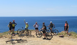 Eine Gruppe Radler steht an einer Steilküste in der Südlichen Ägäis von Griechenland