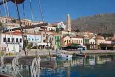 Blick in den Hafen mit angelegten Fischerbooten in der griechischen Stadt Symi in der südlichen griechischen Ägäis