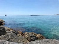 Türkisgrün schimmert das Meer an einer Felsküste bei San Remo.