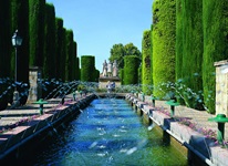 Blick auf einen Park mit großem Springbrunnen und einer Allee in Cordoba in Andalusien