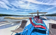 Blick auf das teilweise überdachte Sonnendeck mit Liegen und eine Rettungsboot auf dem Deluxeschiff Andela Lora