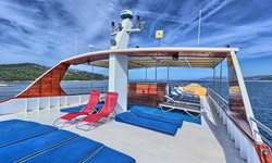 Blaue Liegematten und rote Liegestühle auf dem Sonnendeck der Andela Lora.