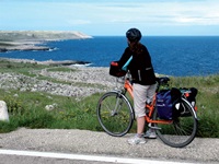 Eine Radlerin genießt den Blick auf die wunderschöne Küste Apuliens.