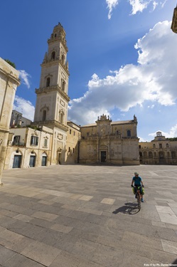Ein Radler fährt an der Kathedrale von Lecce vorbei.