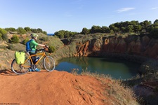 Ein Radfahrer bestaunt die rote Erde in einem alten Bauxit-Steinbruch bei Otranto, der mittlerweile zu einem See geworden ist.