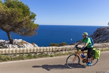 Ein Radfahrer auf einer Küstenstraße im Salento.