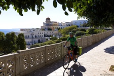 Ein Radfahrer fährt in Santa Cesarea Terme über eine Brücke. Im Hintergrund ist die bunte Villa Sticchi mit ihrer markanten Kuppel zu erkennen.
