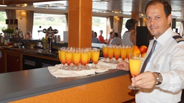 Ein Crewmitglied der MS Arlene II präsentiert Getränke an der Bar der MS Arlene II.