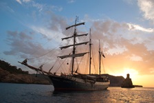 Das Tallship Atlantis ankert bei Sonnenuntergang in einer Bucht.