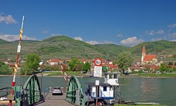 Ein Auto wartet am Donauufer in der Wachau auf die Ankunft der Autofähre.