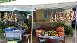Ein Junge verkauft Gemüse an einem Marktstand.
