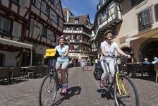 Zwei Radlerinnen genießen die Fahrt durch die Altstadt Colmars.