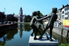 Eine Statue mit drei Kindern, zwei Mädchen, die an einem Jungen zerren, in Belgien in der Region Flandern