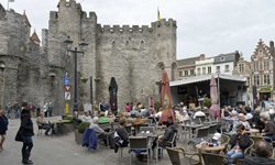 Touristen vor sitzen an einem Kisosk bei der Burg Gravensteen in Gent in Belgien