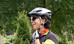 Eine Radfahrerin schließt den Kinnriemen ihres Helms.