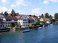 Blick auf eine Häuserreihe am Bodensee mit jeweils einem anglegten Boot