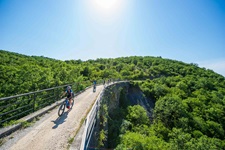Zwei Mountainbiker fahren über eine Brücke in wunderschöner Landschaft von Kroatien