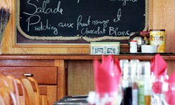 Blick über den eingedeckten Tisch zur Menütafel auf der Caprice
