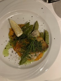 Ein mit Fisch, Zuckerschoten und Dill angerichteter Teller