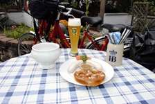 Ein Tisch mit bayrischem Frühstück: Weißwurst mit süßem Senf, Brezel und einem Weizen