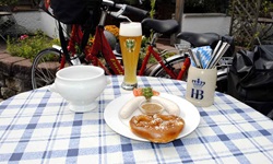 Ein Tisch mit bayrischem Frühstück: Weißwurst mit süßem Senf, Brezel und einem Weizen