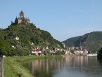 Die hoch thronende Reichsburg Cochem, leicht links darunter die sogenannte Pestkapelle und das Moselufer mit der Promenade Cohems