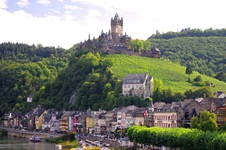 Blick auf die Promenade von Cochem und auf die hoch thronende Reichsburg und links darunter die Pestkapelle