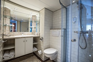 Blick in ein Badezimmer mit Dusche, Toilette, Waschtisch und Spiegel auf der MS Swiss Crown