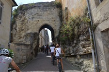 Eine Radlergruppe durchquert auf dem Weg von Bourg-sur-Gironde nach Blaye ein steinernes Tor.