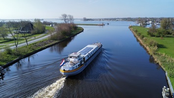 Die MS Lena Maria fährt einen Kanal in Nord-Holland entlang