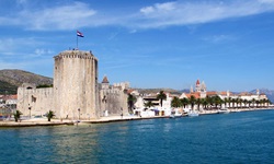 Der Hafen von Trogir mit der Festung, einer markanten Palmenreihe und dem Turm der Johannes-Kirche.