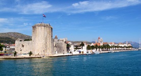 Der Hafen von Trogir mit der Festung, einer markanten Palmenreihe und dem Turm der Johannes-Kirche.