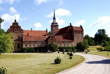 Eine Gruppe Radler fährt auf ein imposantes Schloss zu.