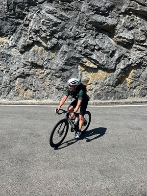 Ein Radfahrer auf einer Straße an einem Berg auf der Alpenpanorama-Route in der Schweiz