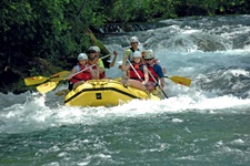 Eine Gruppe von Touristen versuchen sich beim Rafting