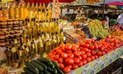 Gurken, Tomaten, Trauben und verschiedene Öle werden an einem Marktstand in Split zum Kauf angeboten.