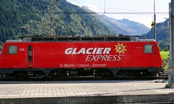 Blick auf die rote Bahn "Glacier Express" von St. Moritz / Davos nach Zermatt in Disentis am Bahnhof